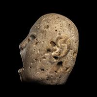 An Aztec Stone Head of the Deity Xipe Totec
