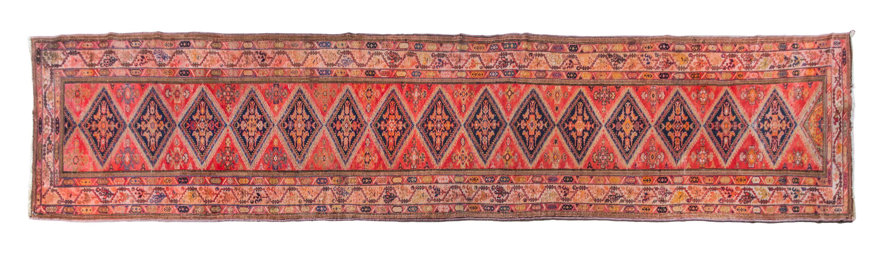 A Persian Wool Runner 20 feet 2 inches x 3 feet 3 inches.