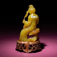A Chinese Yellow Jade Seated Figure of a Lady, Late Qing Dynasty — 清晚期 黃玉持蓮仕女