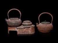Seven Japanese Cast Iron Teapots, Tetsubin, and Burner