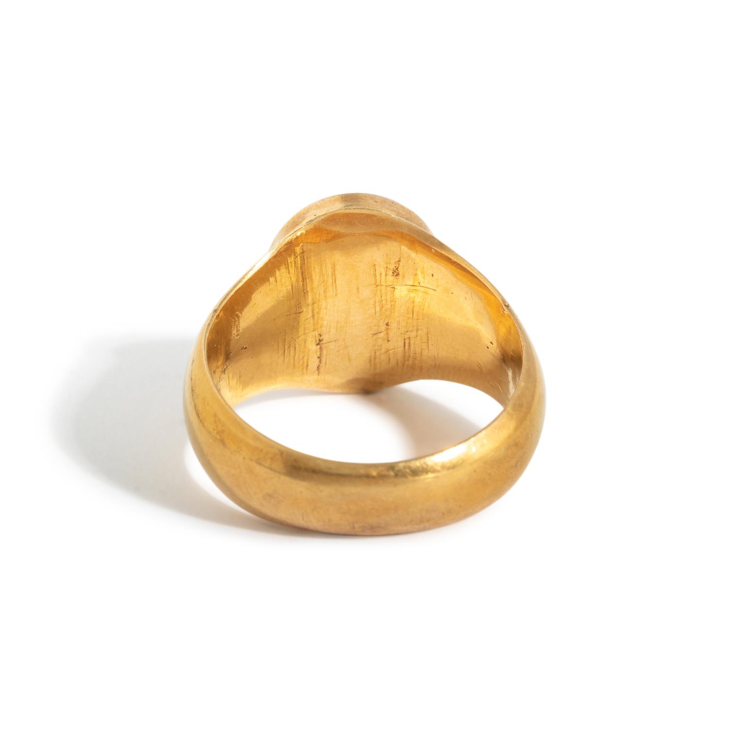 A Roman Gold and Plasma Finger Ring with a Figure Holding Tools and an Inscription