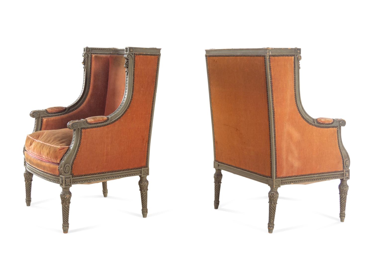 A Pair of Louis XVI Carved and Painted Walnut Bergères à L'Oreilles