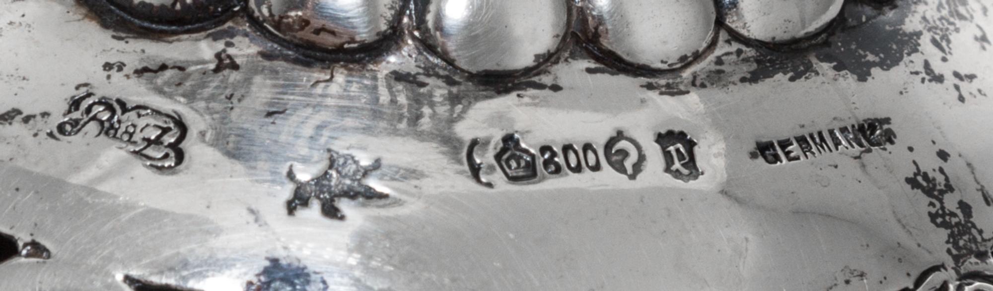 A Set of Three German Silver Goblets, 19th/20th Century, each pierced bowl with four vacant cartouches, raised on a figural stem in the