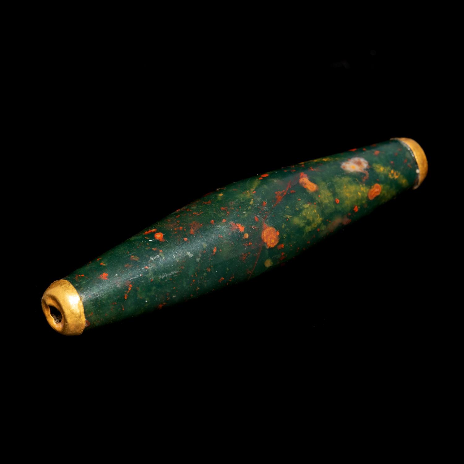 A Near Eastern Bloodstone Bead with Gold Caps