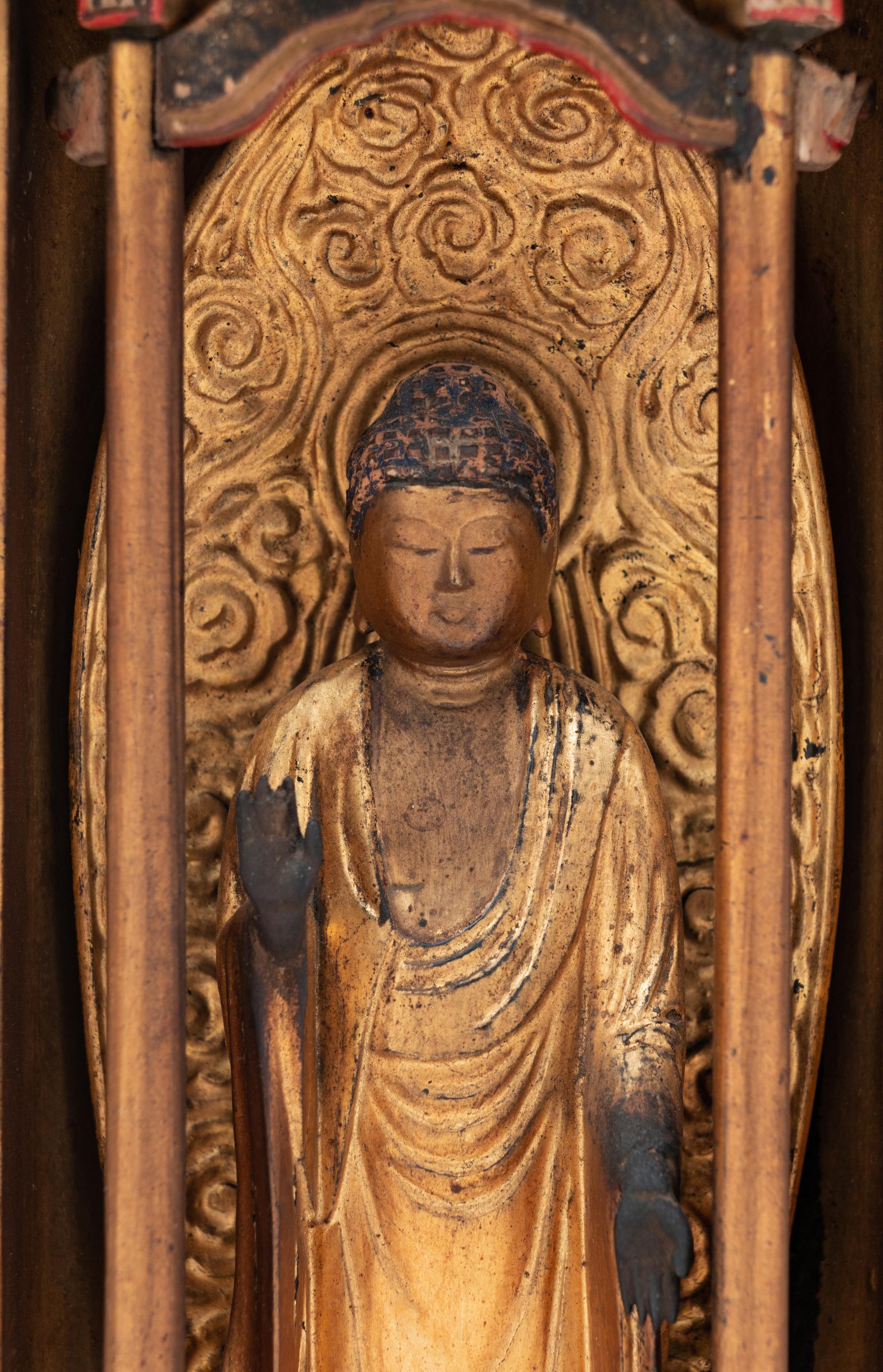 A Black and Gilt Lacquered Wood Shrine with a Gilt Wood Figure of Standing Buddha