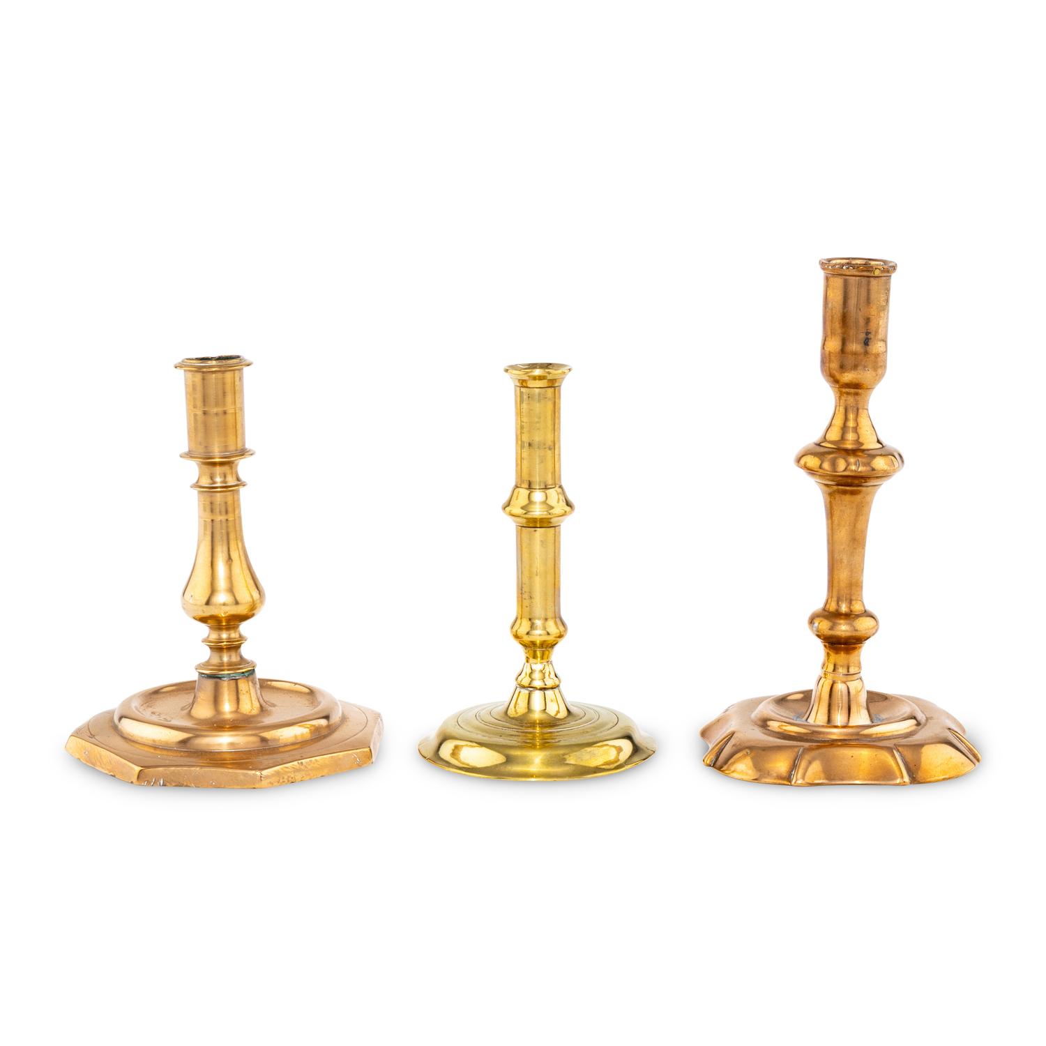 A Collection of Three Brass and Bell Metal Candlesticks