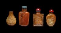 Four Chinese Carved Russet Jade and Hardstone Snuff Bottles