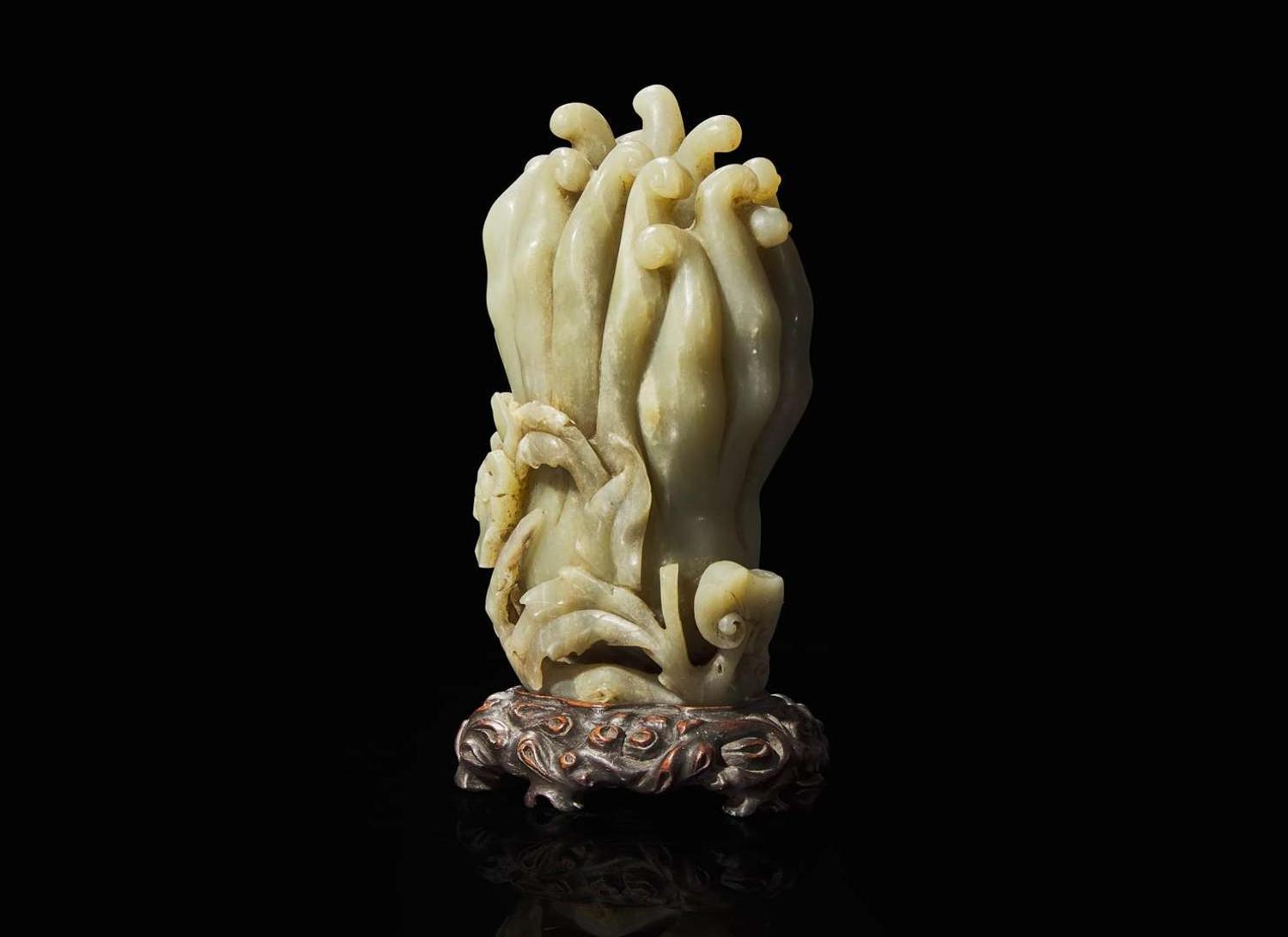 A Chinese carved celadon jade Buddha’s-hand citron with carved wood stand, Qing dynasty 玉雕佛手瓜帶底座 清