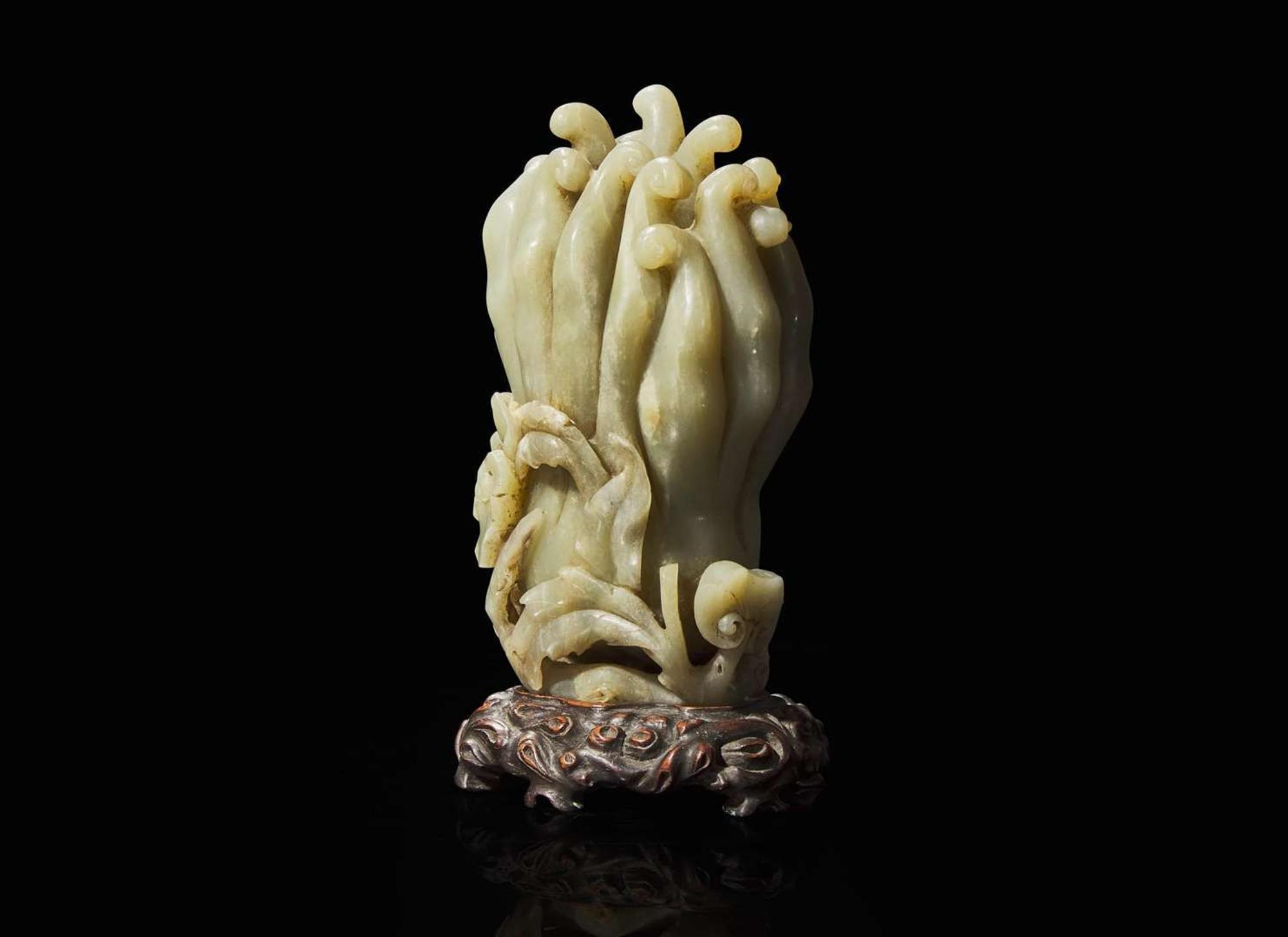 A Chinese carved celadon jade Buddha’s-hand citron with carved wood stand, Qing dynasty 玉雕佛手瓜帶底座 清