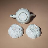 A Chinese Blanc-de-Chine Molded Porcelain Covered Teapot and a Pair of Molded Floriform Bowls, 18th Century — 清中期 德化白瓷貼塑松鼠葡萄茶壺及茶碗一對