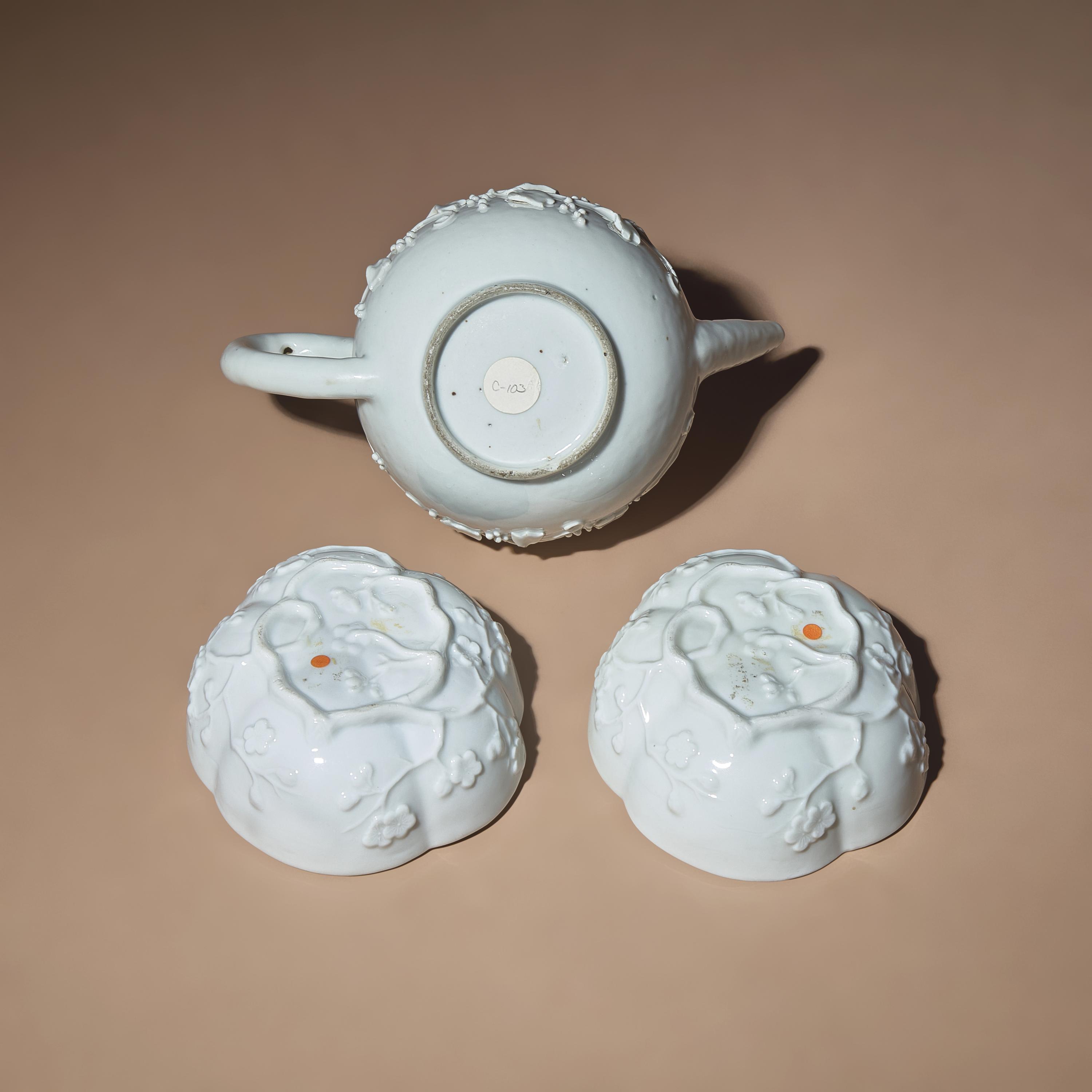 A Chinese Blanc-de-Chine Molded Porcelain Covered Teapot and a Pair of Molded Floriform Bowls, 18th Century — 清中期 德化白瓷貼塑松鼠葡萄茶壺及茶碗一對