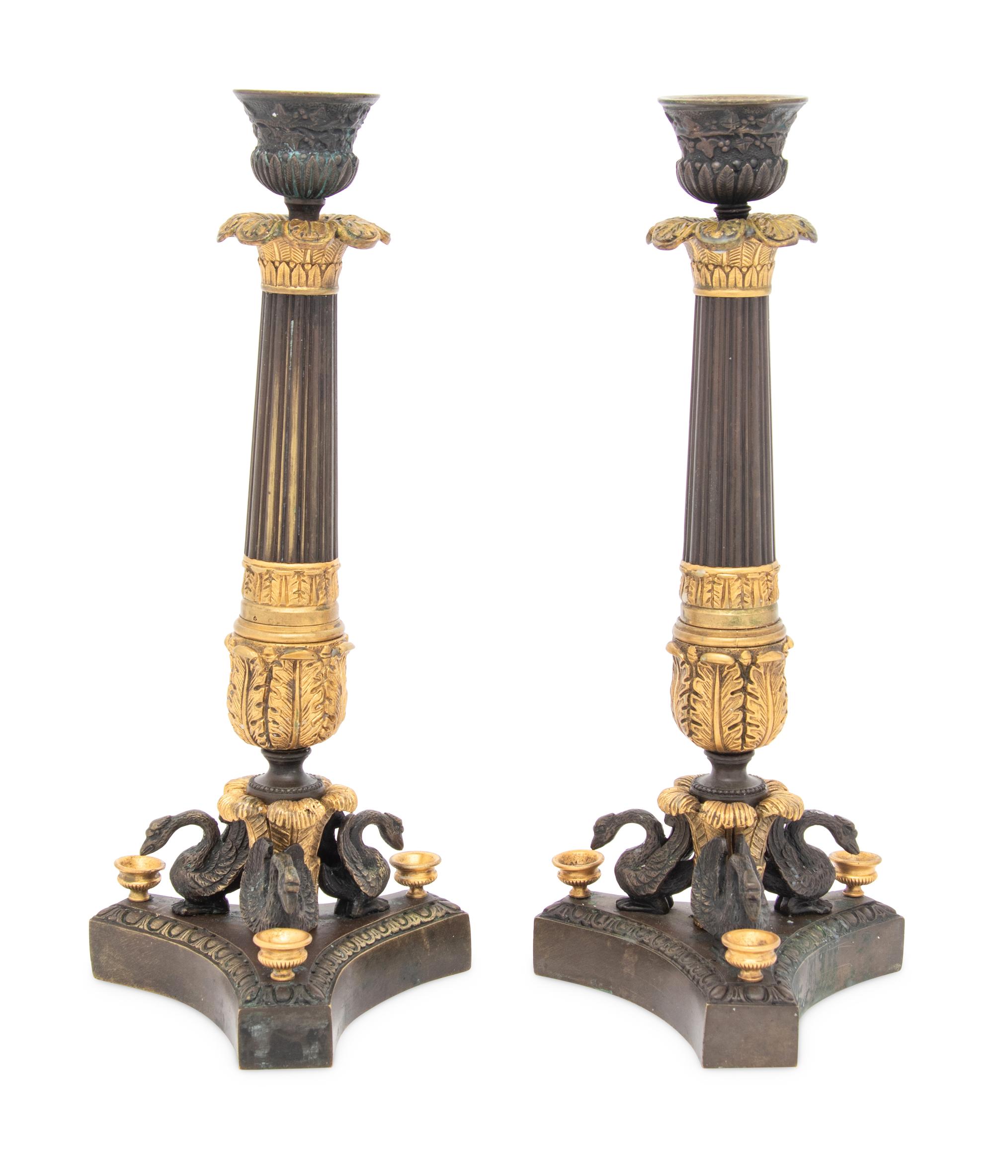 A Pair of French Parcel Gilt and Patinated Bronze Candlesticks