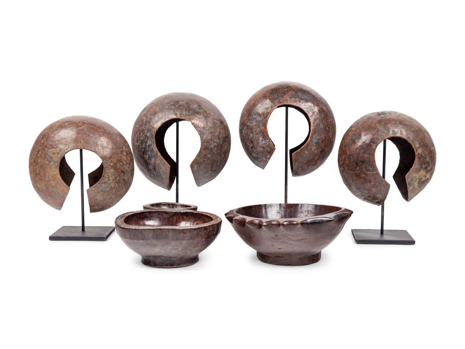 A Pair of Philippine Carved Wood Bowls and Four African Bronze Currency Bracelets on Metal Stands
