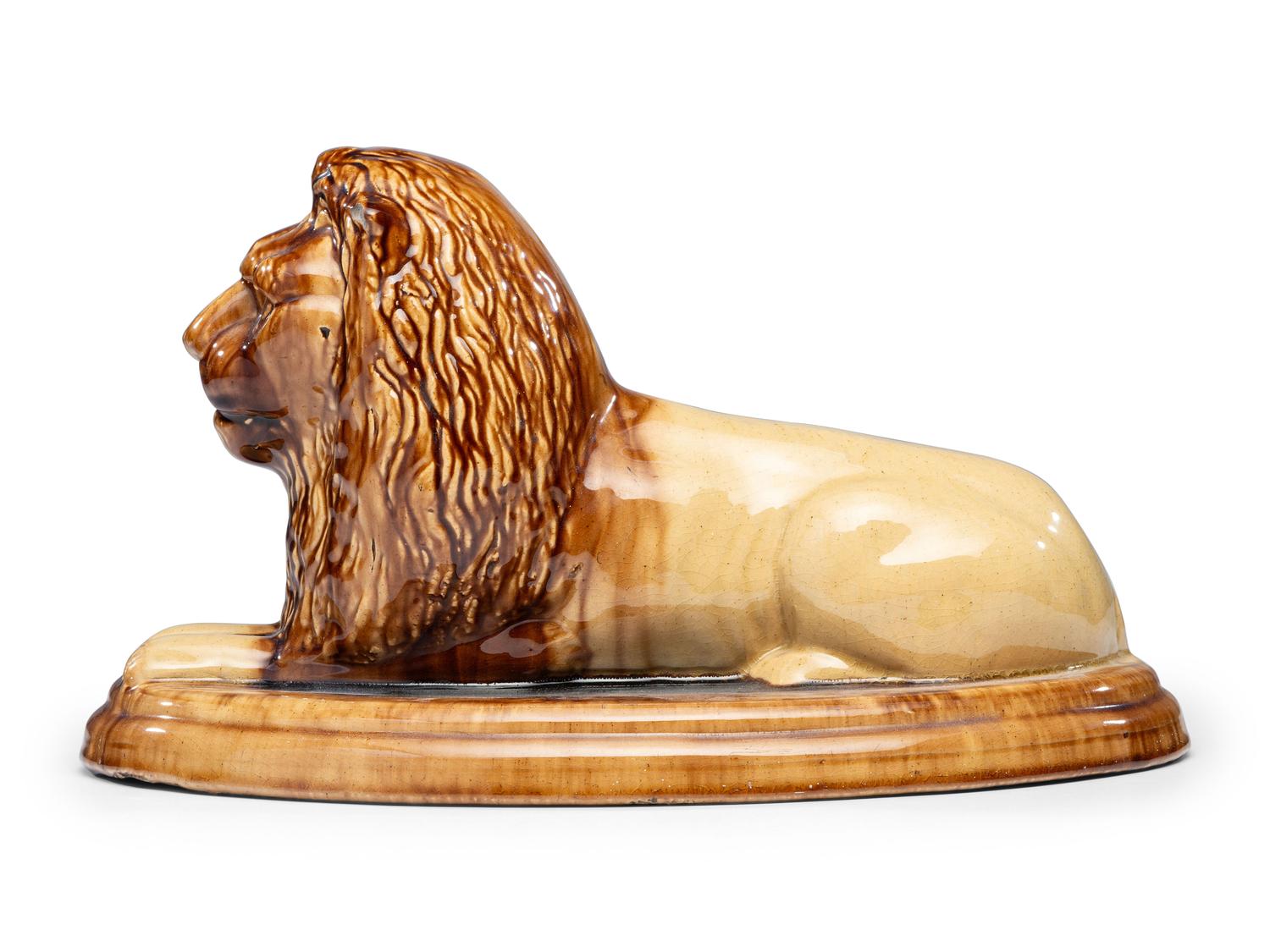 A Yellowware Recumbent Lion Figure