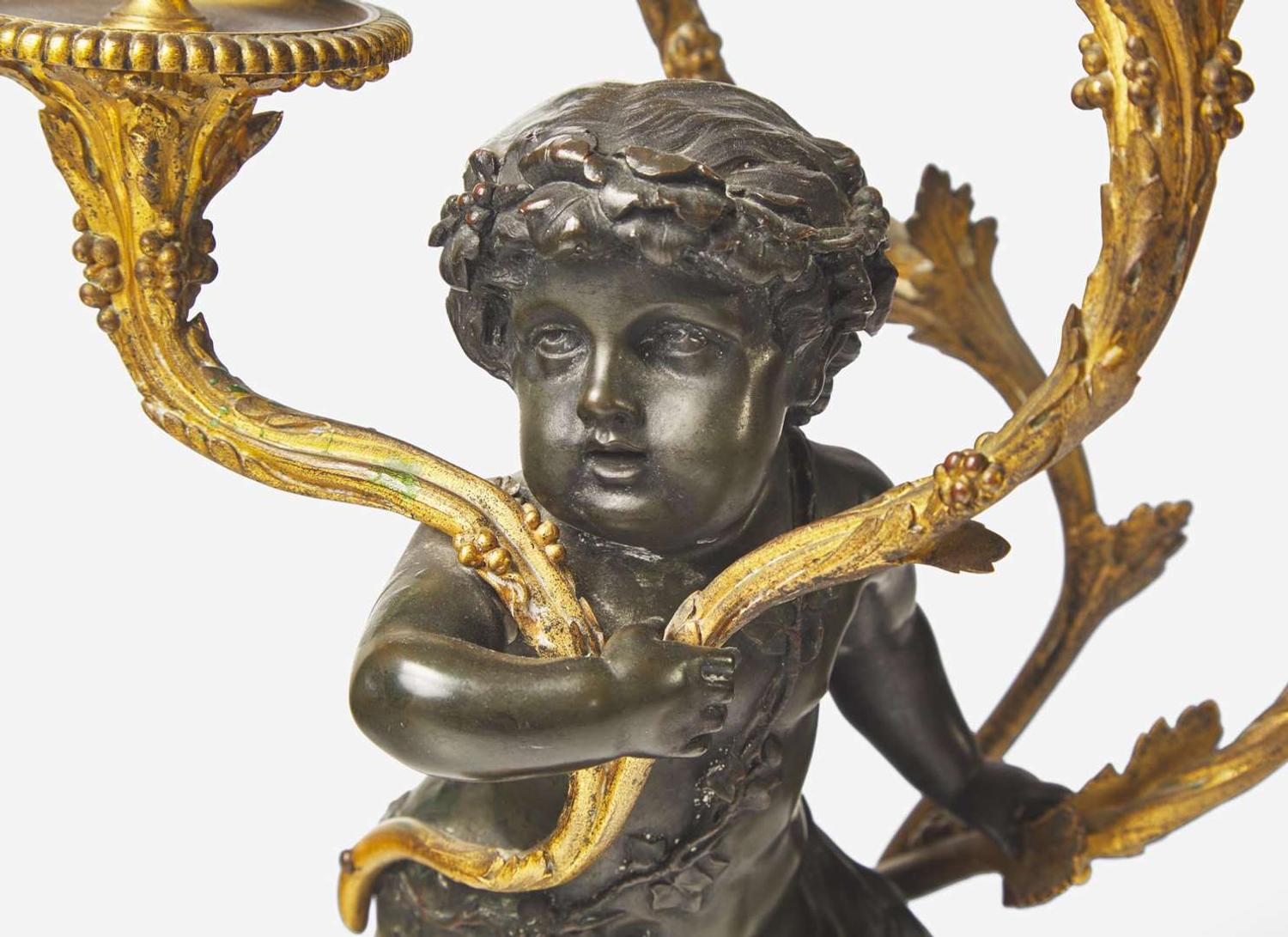 A pair of Louis XVI style gilt and patinated bronze candelabras depicting fauns, late 19th century