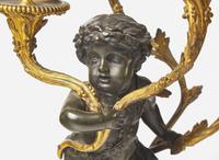A pair of Louis XVI style gilt and patinated bronze candelabras depicting fauns, late 19th century