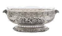 A German Silver Center Bowl, , having pierced floral and C-scroll decoration interspersed with two cartouches depicting putti in a gard