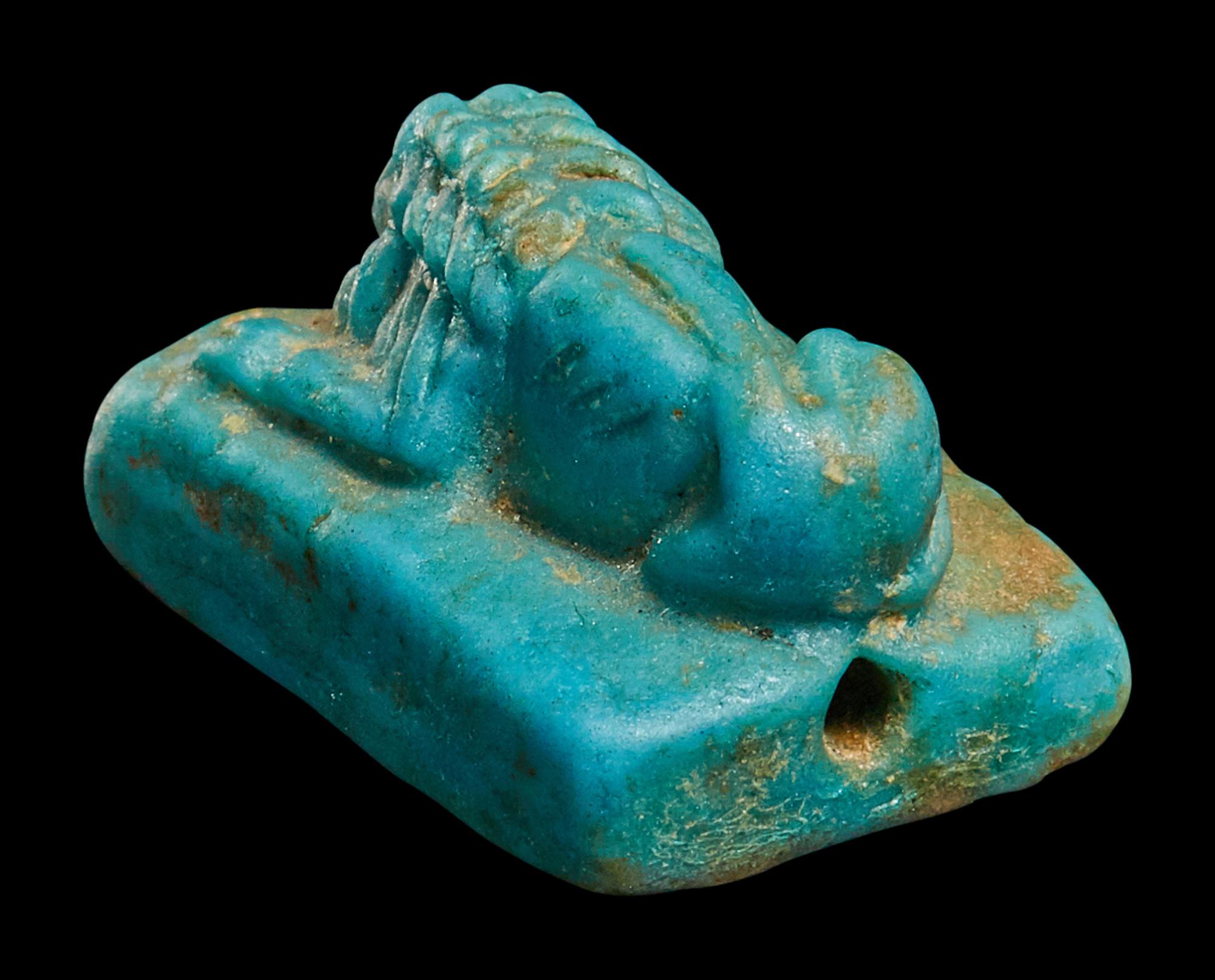 An Egyptian Faience Recumbent Lion Bead