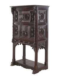 A Gothic Revival Carved Walnut Cabinet on Stand