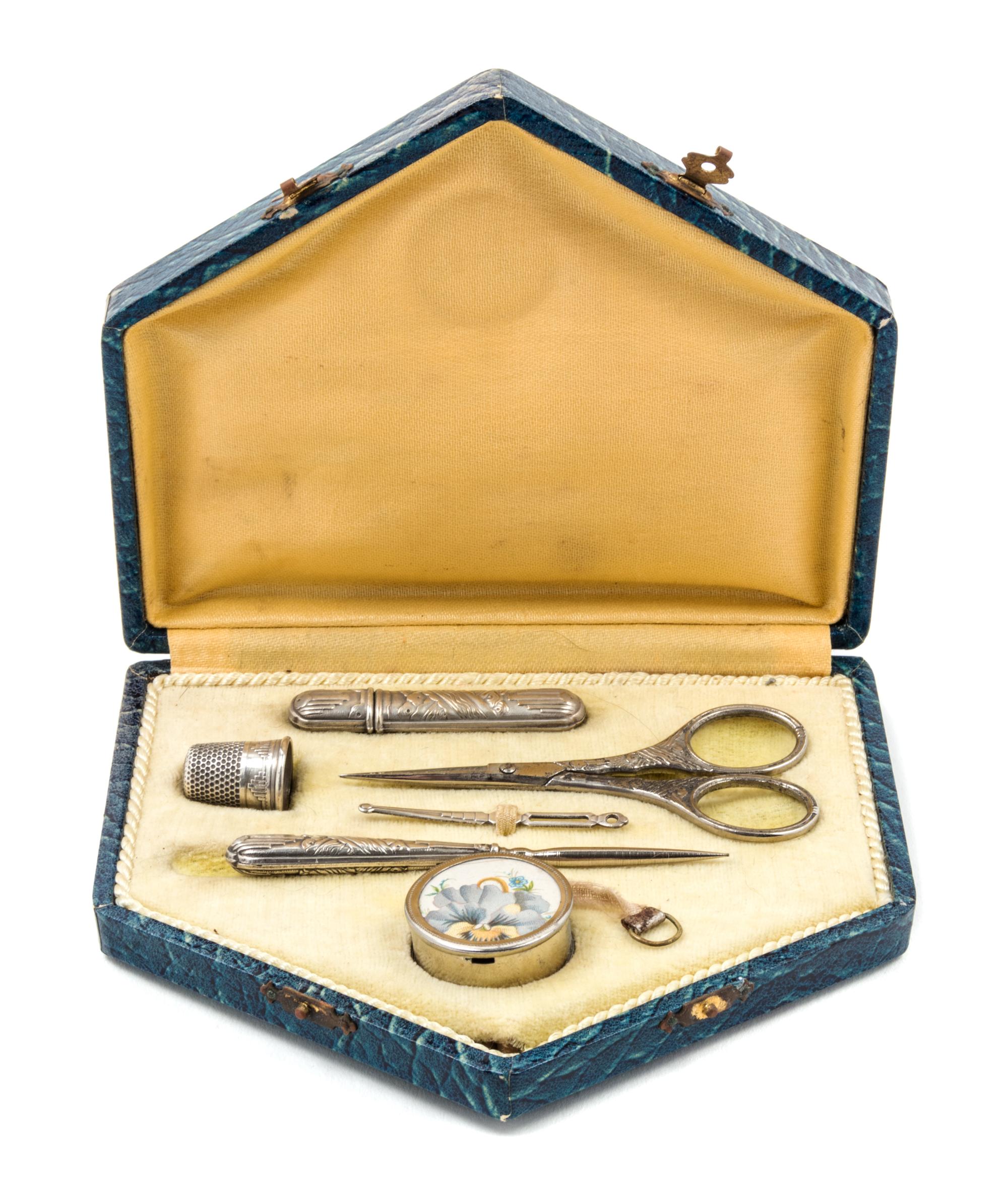 An Art Deco Silvered Metal Sewing Kit, , fitted with a needle case, bodkin, thimble, scissors, stiletto and tape measure.