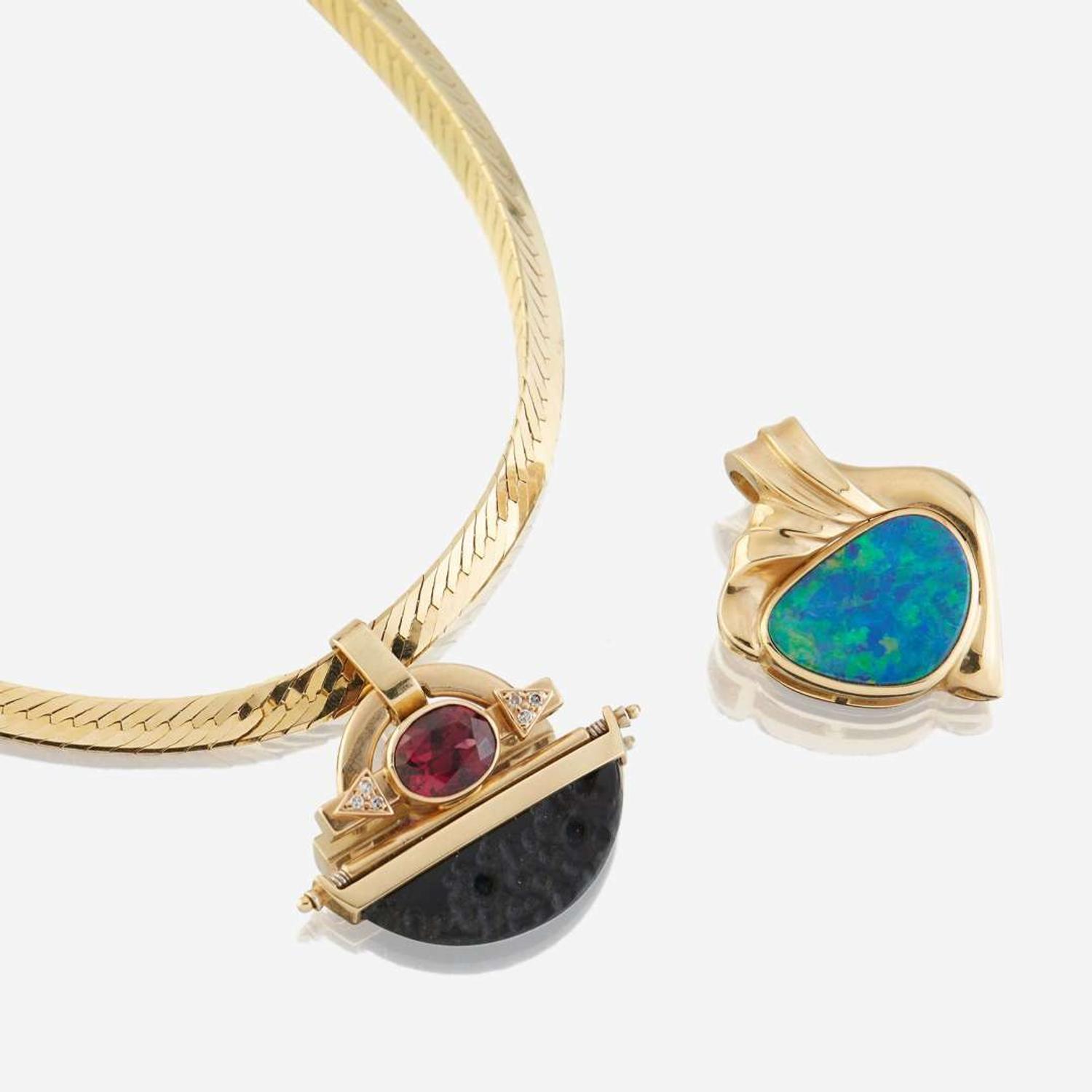 Two fourteen karat gold and gem-set enhancers with necklace