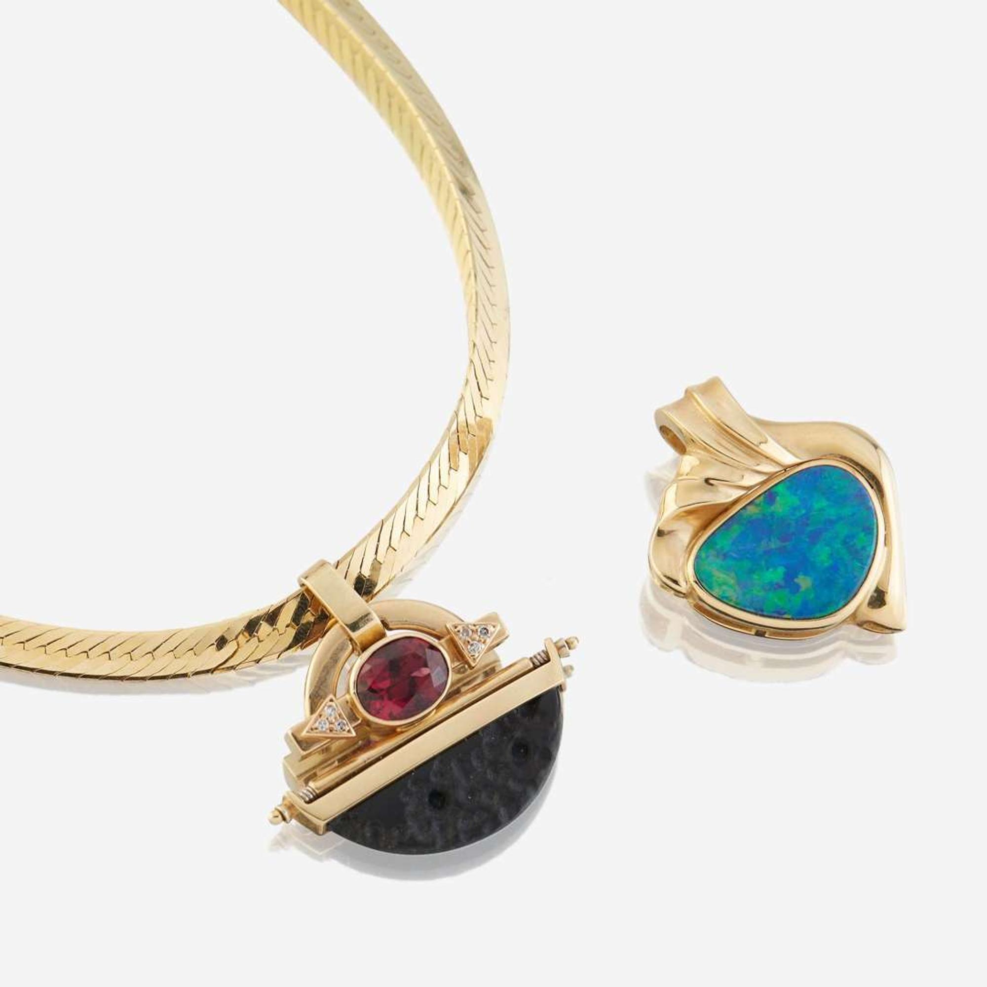 Two fourteen karat gold and gem-set enhancers with necklace