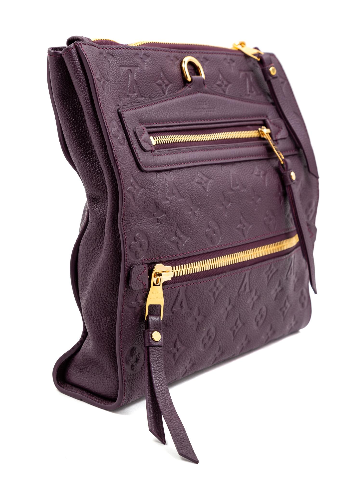 A Louis Vuitton Plum Monogram Empreinte Leather Petillante Clutch, 7" H x 10.75" W x 2.5" D.
