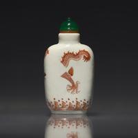 A Chinese Enameled Porcelain "Dragon" Snuff Bottle, Qing Dynasty, Daoguang Period — 清道光 瓷胎礬紅刻暗花龍紋鼻煙壺