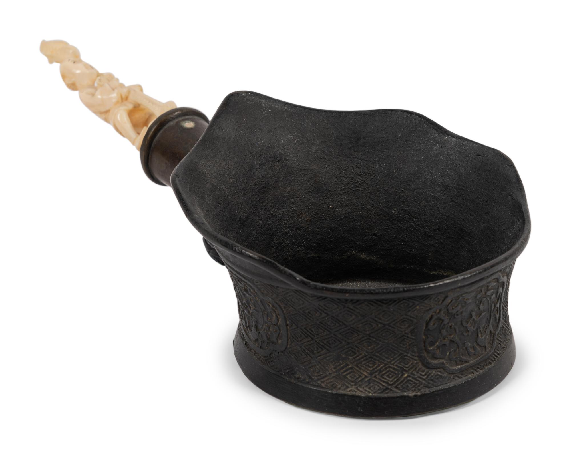 A Chinese Silk Iron with a Figural Handle