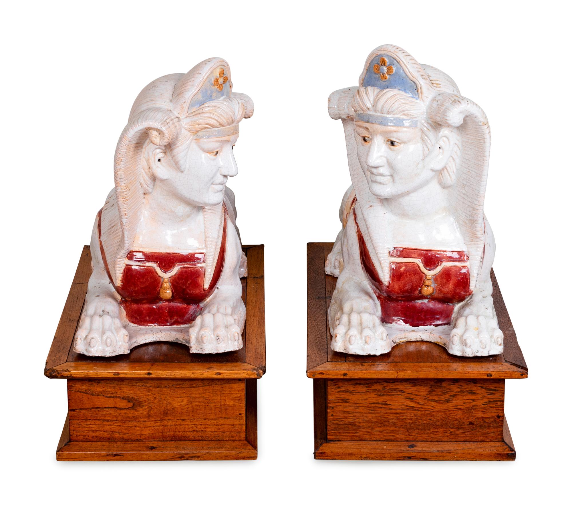 A Pair of Polychromed Ceramic Sphinxes — 20TH CENTURY