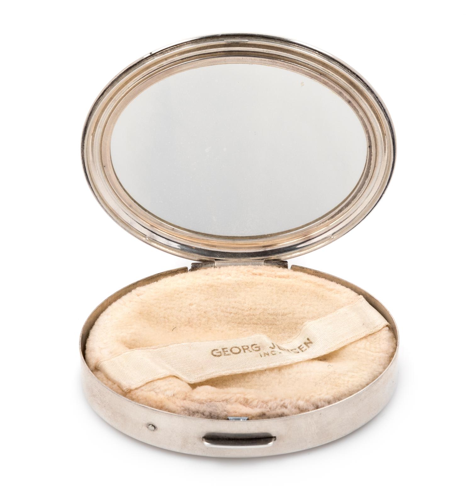 An American Silver Compact, Georg Jensen Inc., New York, NY, Circa 1940, or oval form, the lid with an engraved name and applied foliat