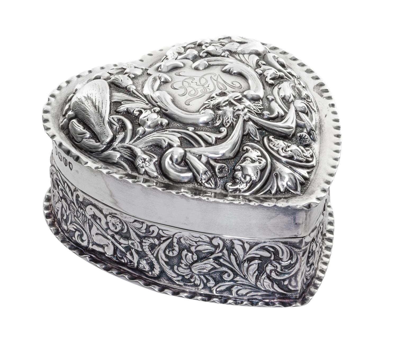 A Victorian Silver Covered Box, William Comyns, London, 1889, in the form of a heart, the lid worked with mask, bird and C-scroll decor