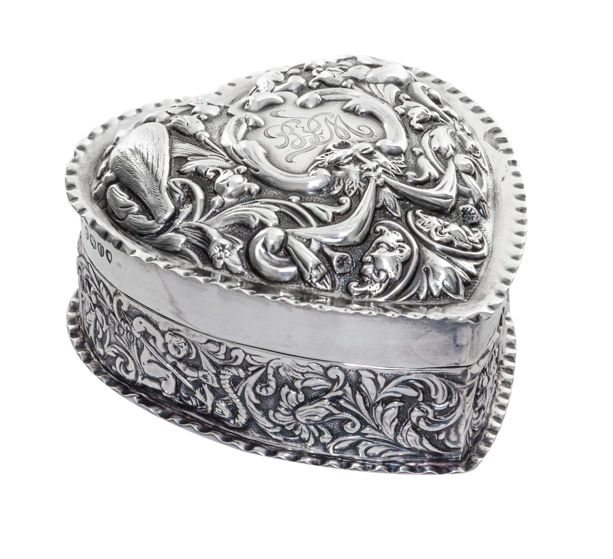 A Victorian Silver Covered Box, William Comyns, London, 1889, in the form of a heart, the lid worked with mask, bird and C-scroll decor