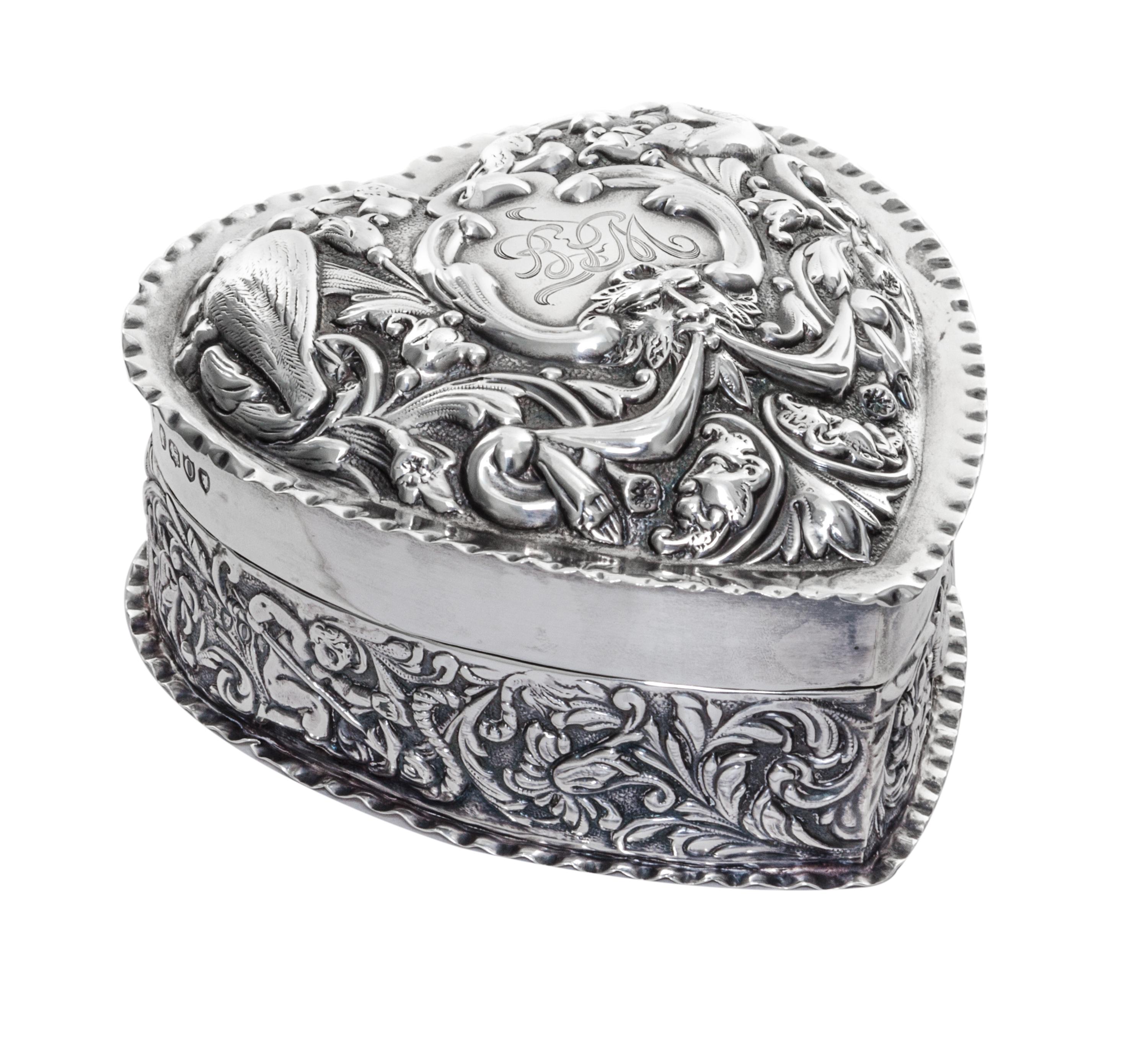 A Victorian Silver Covered Box, William Comyns, London, 1889, in the form of a heart, the lid worked with mask, bird and C-scroll decor