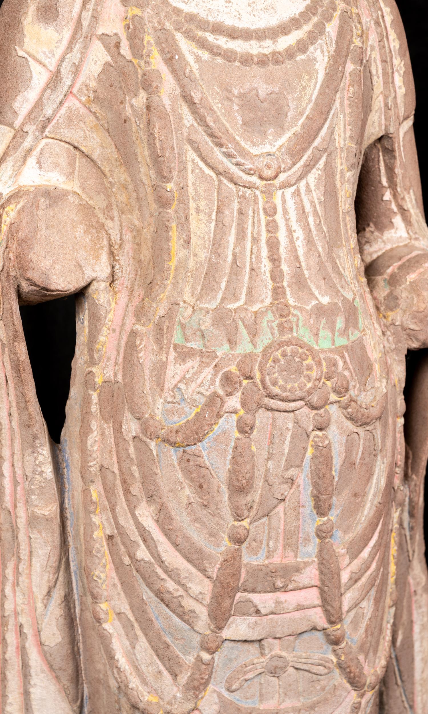 A Chinese Carved Sandstone Buddha with Remnants of Polychrome Decoration