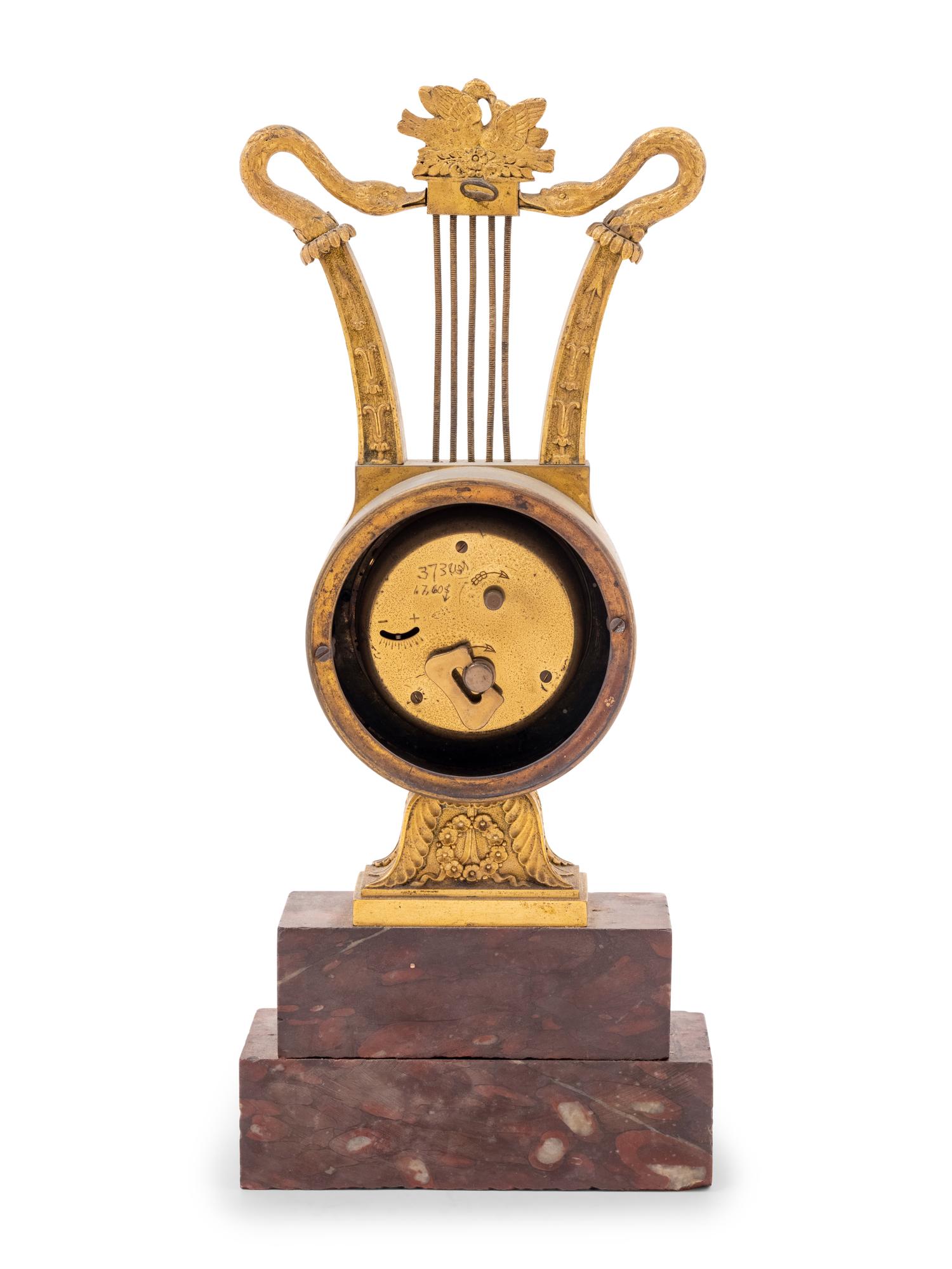 An Empire Style Gilt Bronze and Rouge Marble Clock