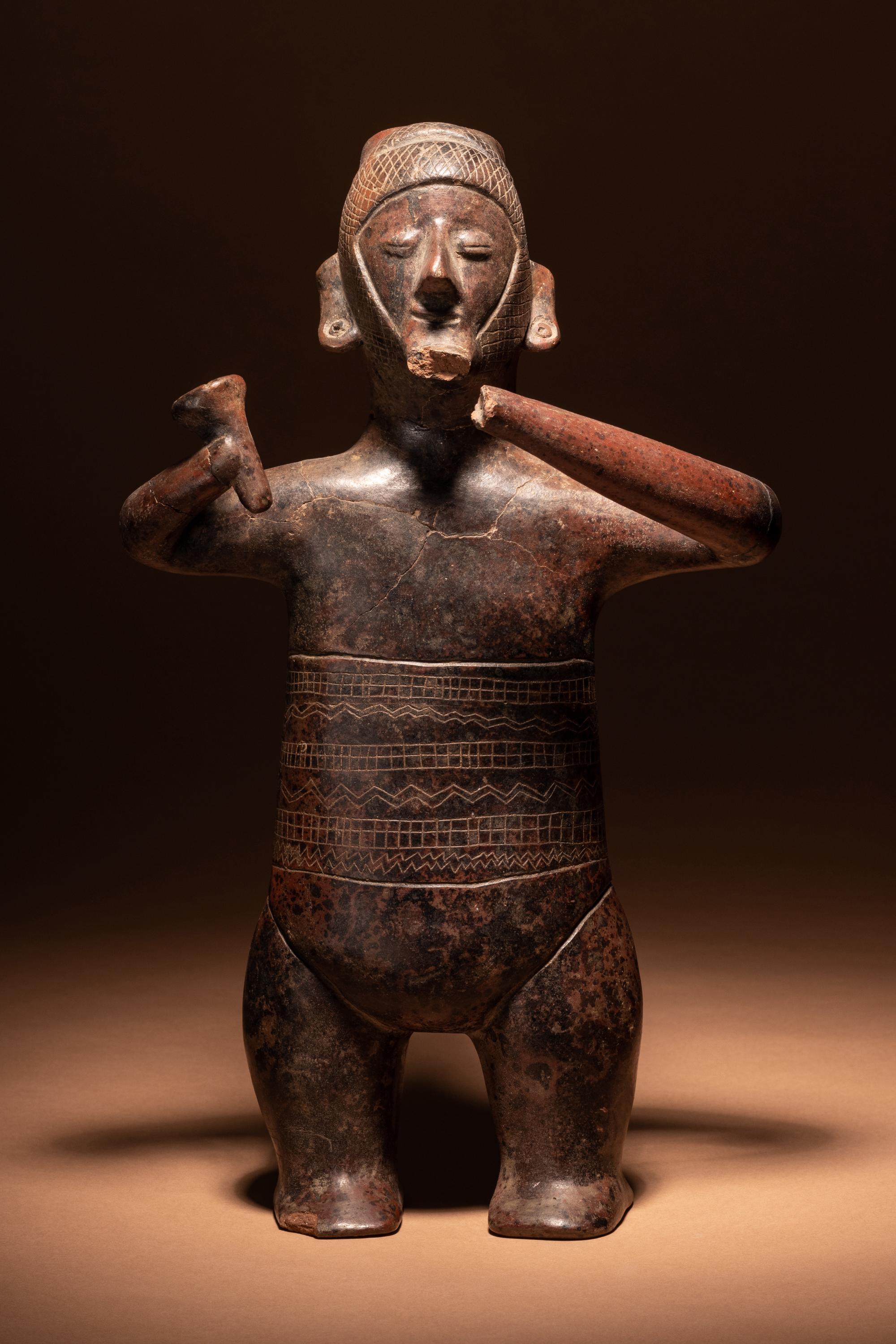 A Colima Terracotta Standing Male Figure with Incised Decoration