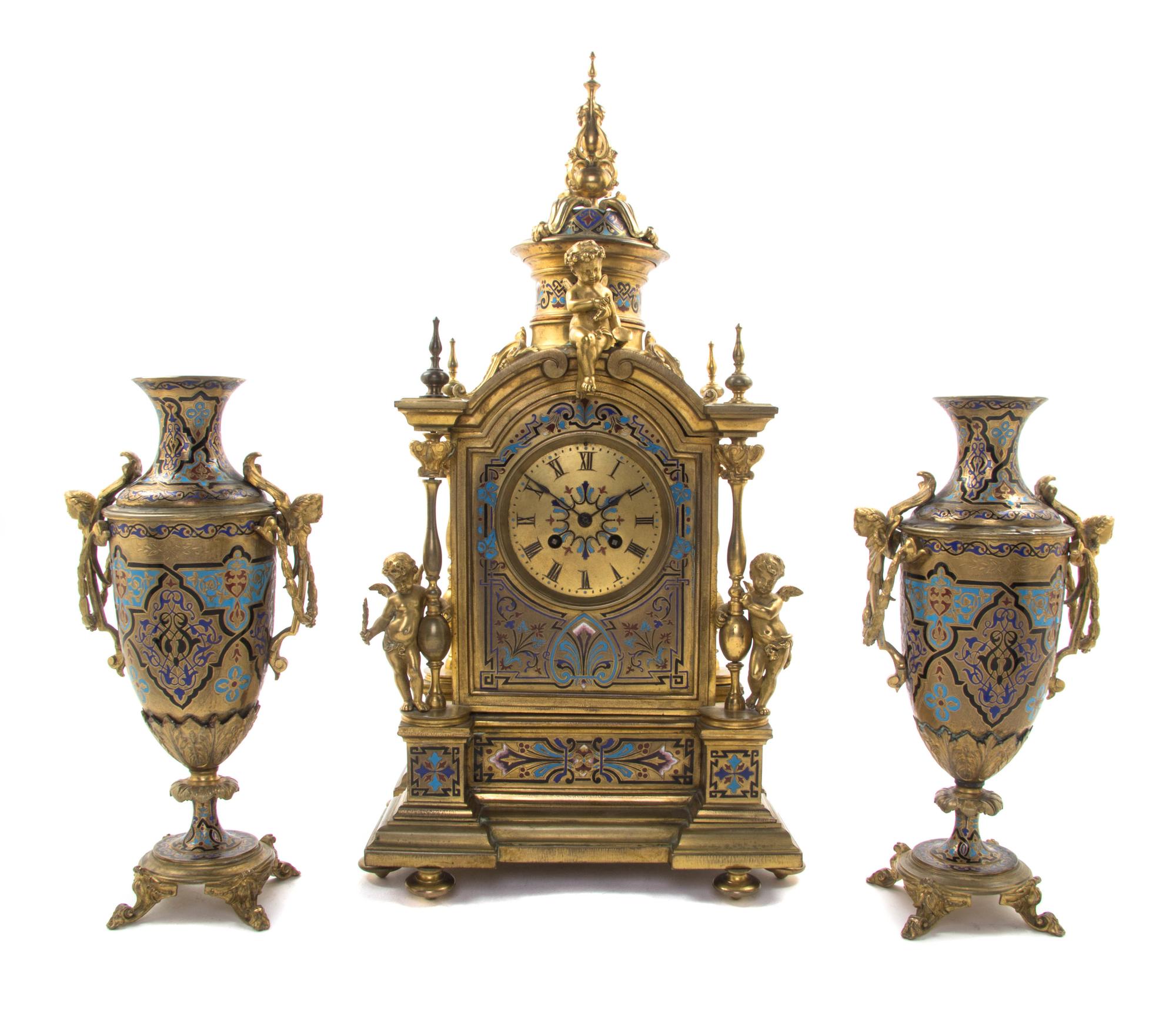 A Continental Gilt Bronze and Champleve Clock Garniture, 19TH/20TH CENTURY, MOVEMENT BY JAPY FRERES, Height of clock 21 inches. — 19TH/20TH CENTURY, MOVEMENT BY JAPY FRERES,