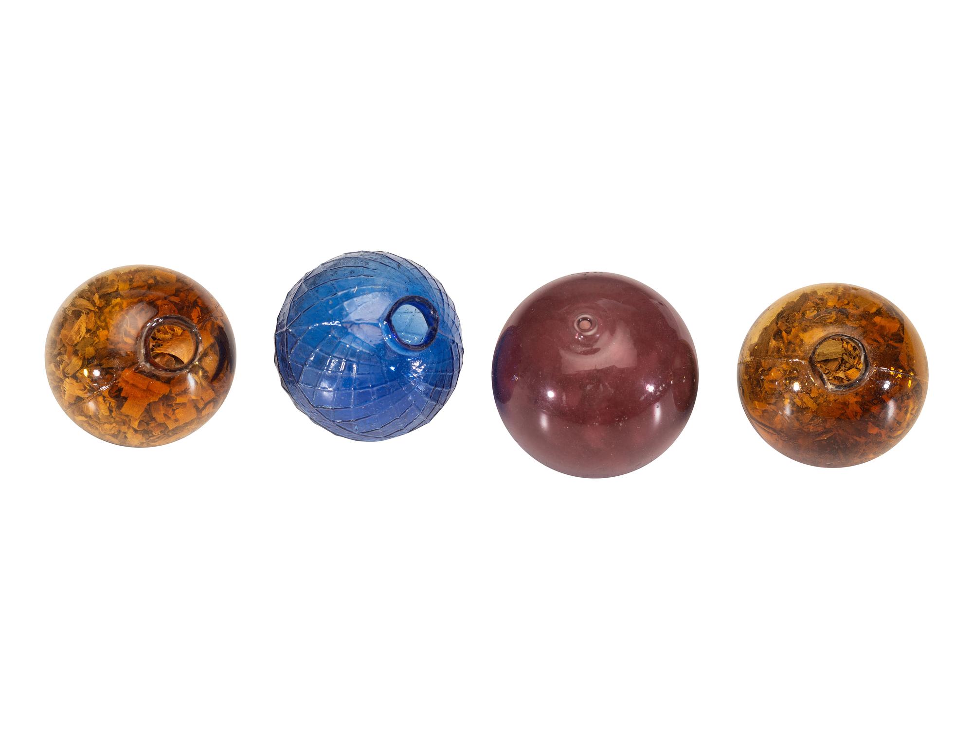 [WILD WEST]. 4 glass target balls. Ca late 19th-early 20th century.