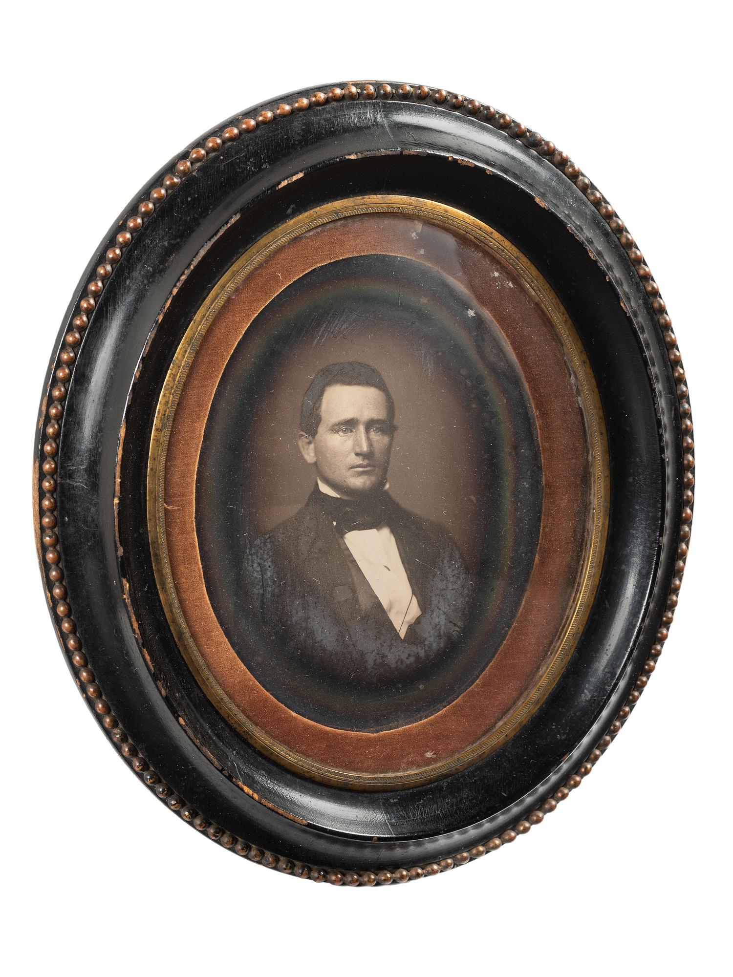 [EARLY PHOTOGRAPHY]. Whole plate daguerreotype of a young man housed in oval wall frame.