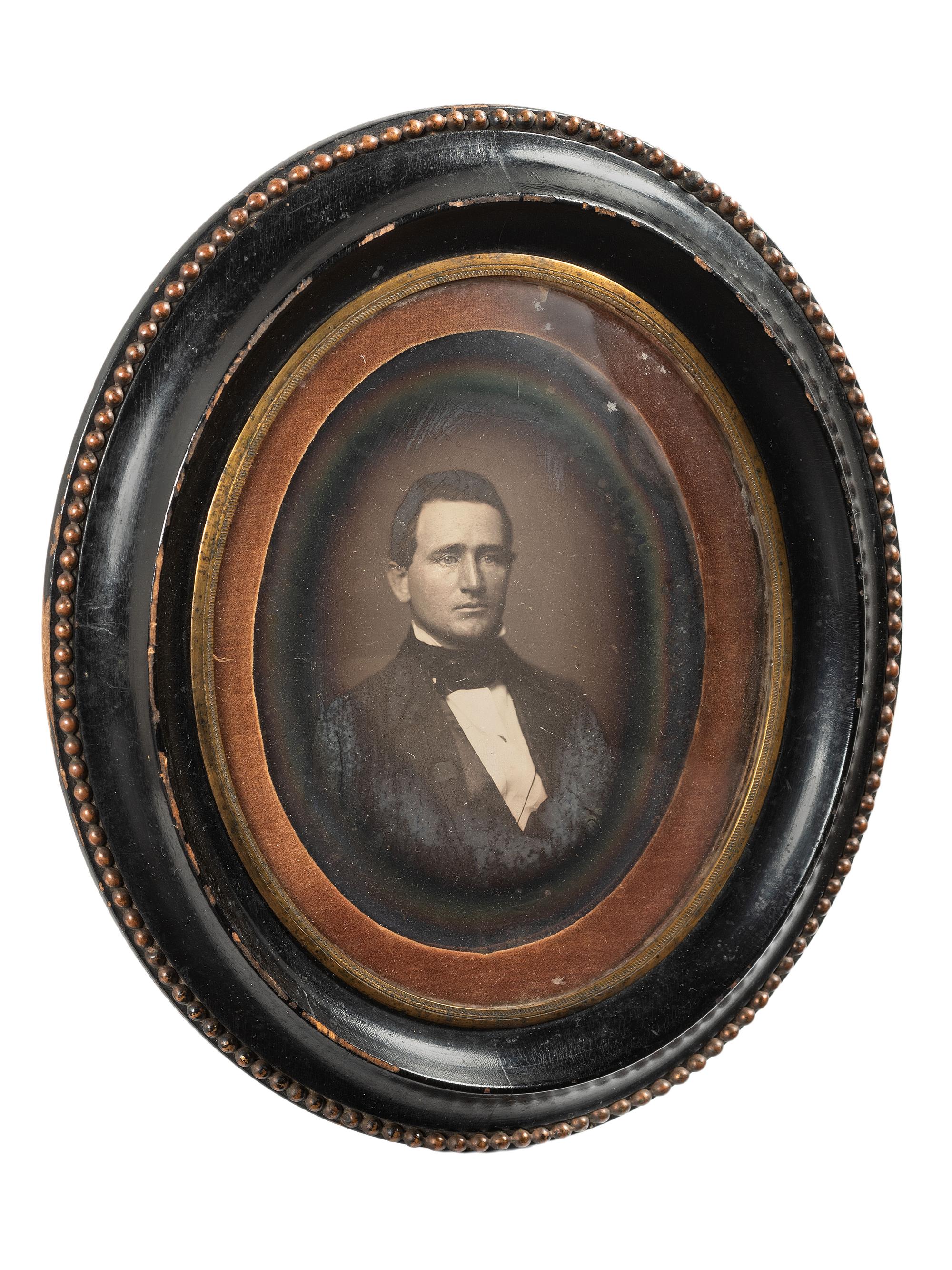 [EARLY PHOTOGRAPHY]. Whole plate daguerreotype of a young man housed in oval wall frame.