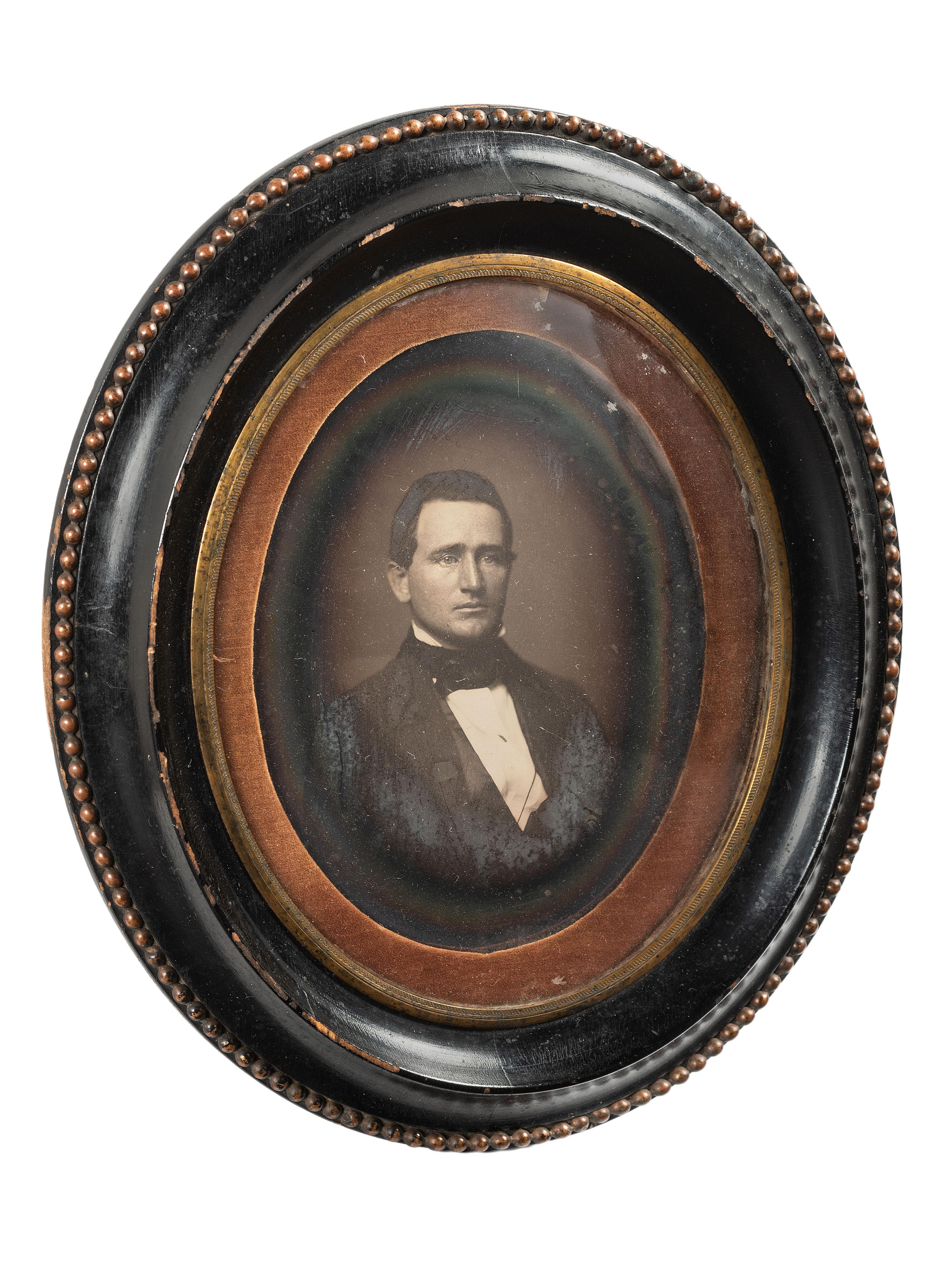 [EARLY PHOTOGRAPHY]. Whole plate daguerreotype of a young man housed in oval wall frame.