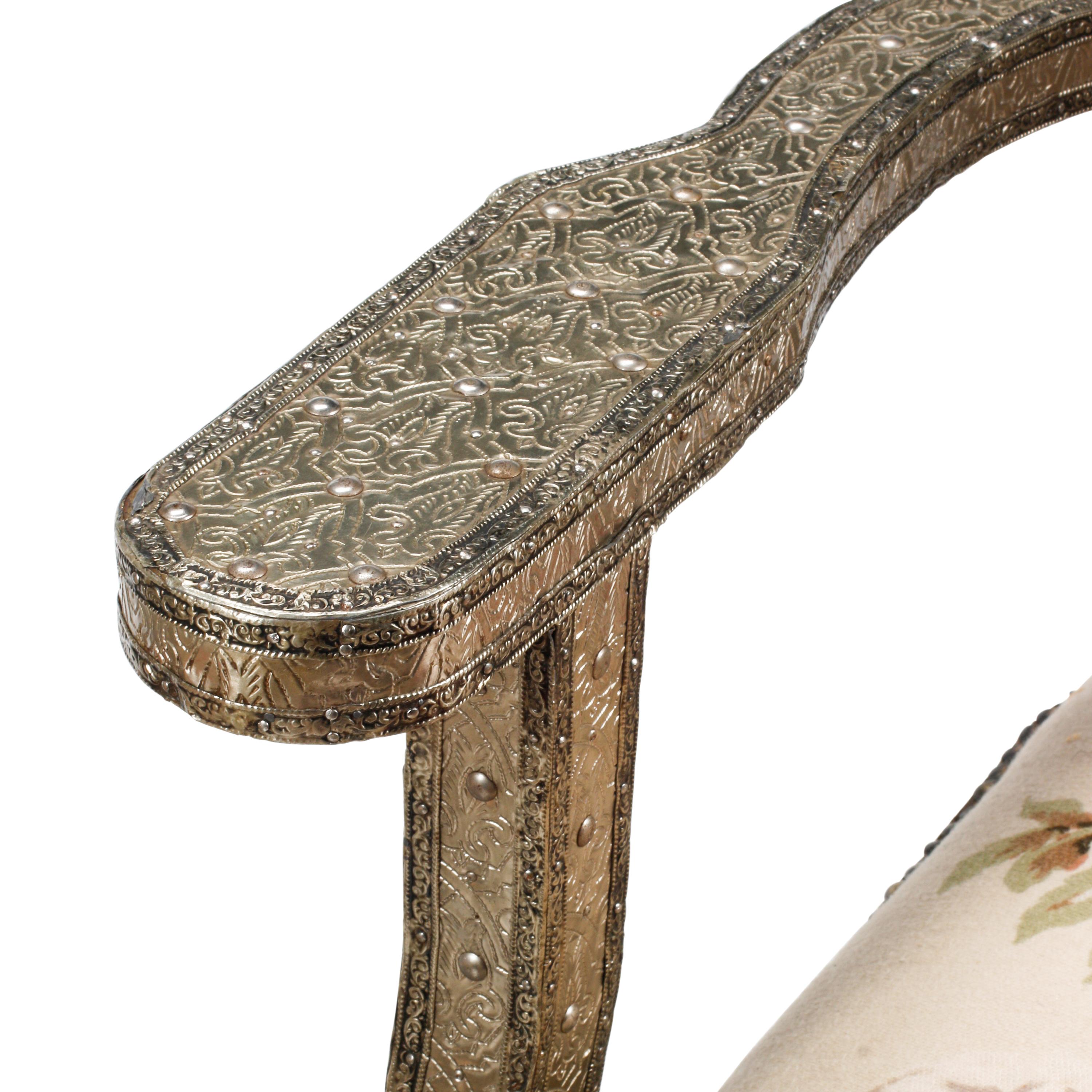 A Pair of Anglo-Colonial Silvered Metal-Clad Swiveling Armchairs
