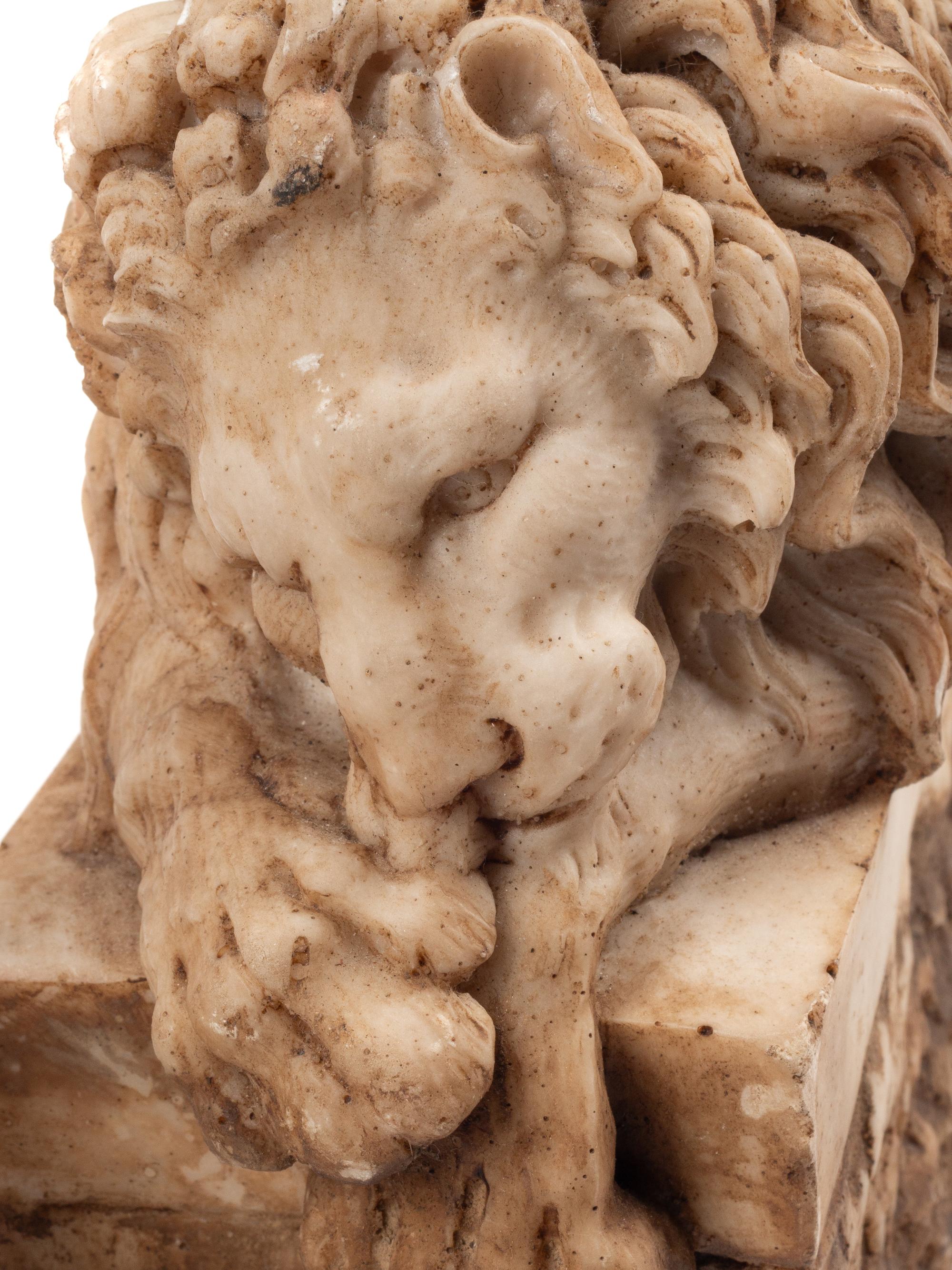 A Pair of Composition Marble Recumbent Lions