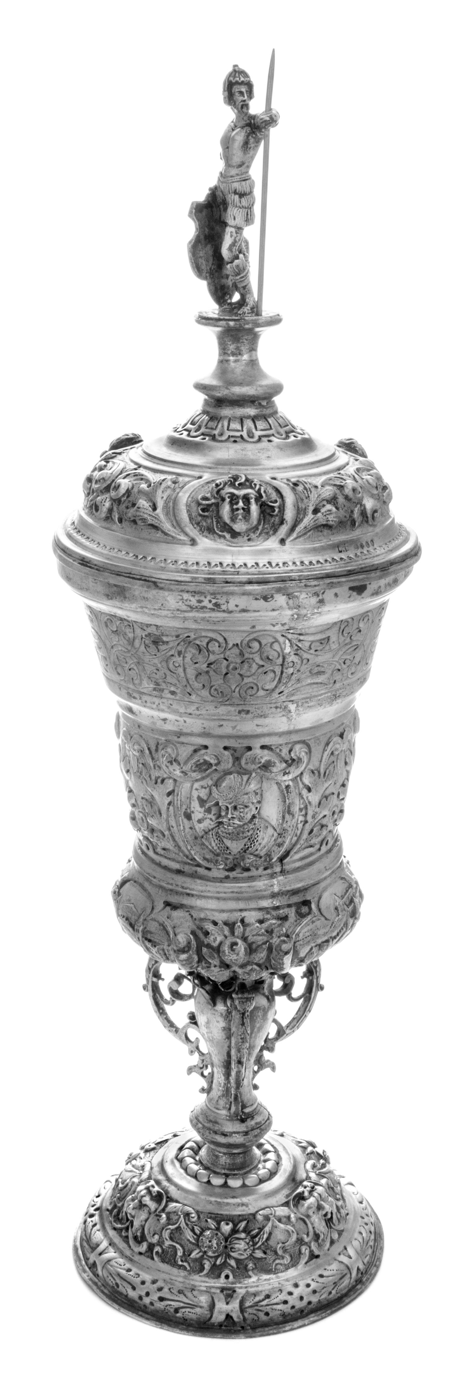 A German Silver Pokal, Hanau, Late 19th Century, surmounted by an armored warrior and worked throughout with repousse masks and foliate