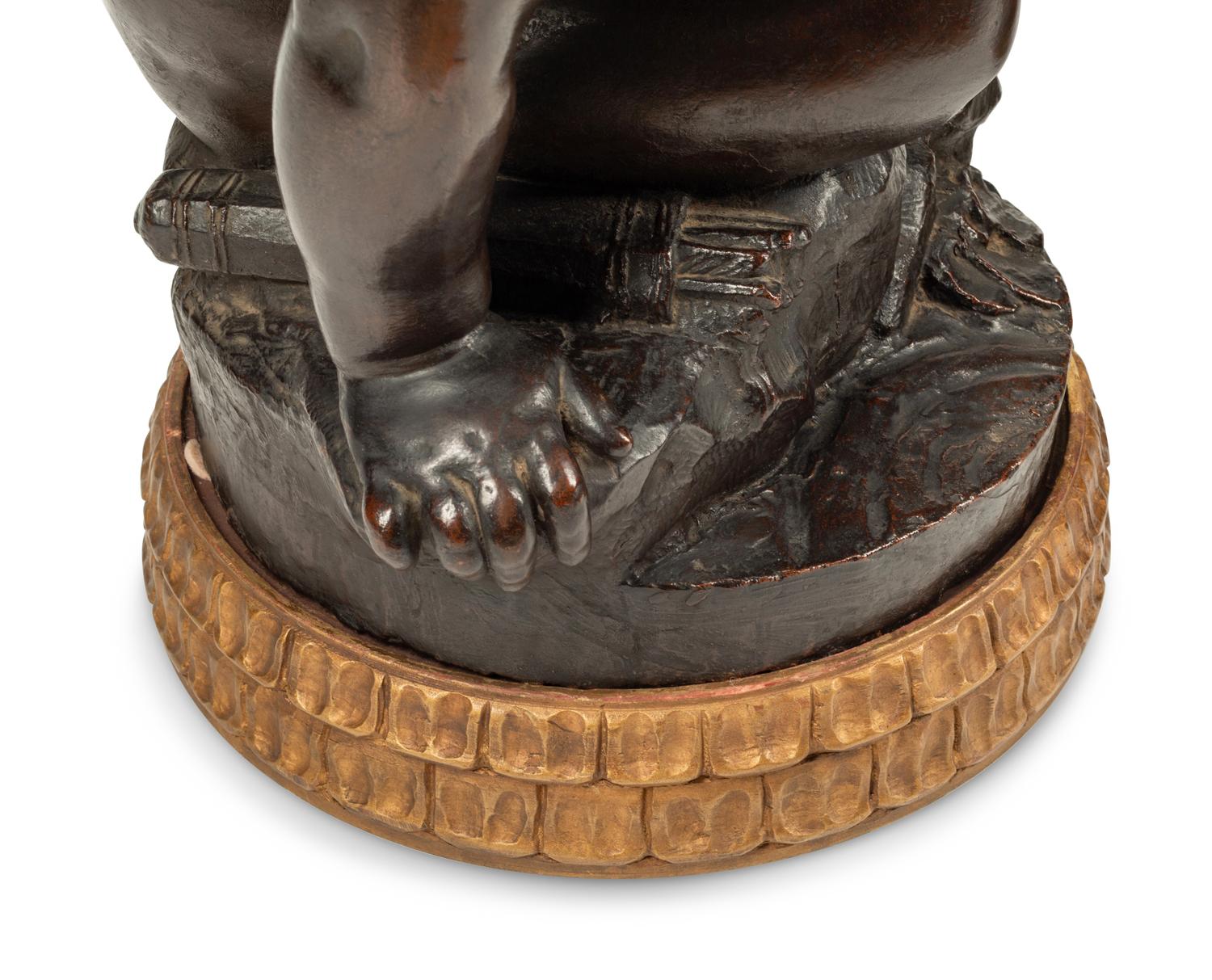 A Pair of Bronzed Composition Figures of Seated Cherubs