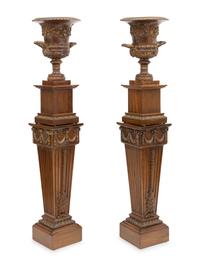 A Pair of Neoclassical Style Carved Campagna Form Urns on Pedestals
