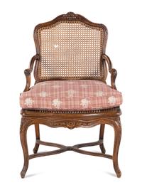 A Régence Carved Walnut and Caned Fauteuil
