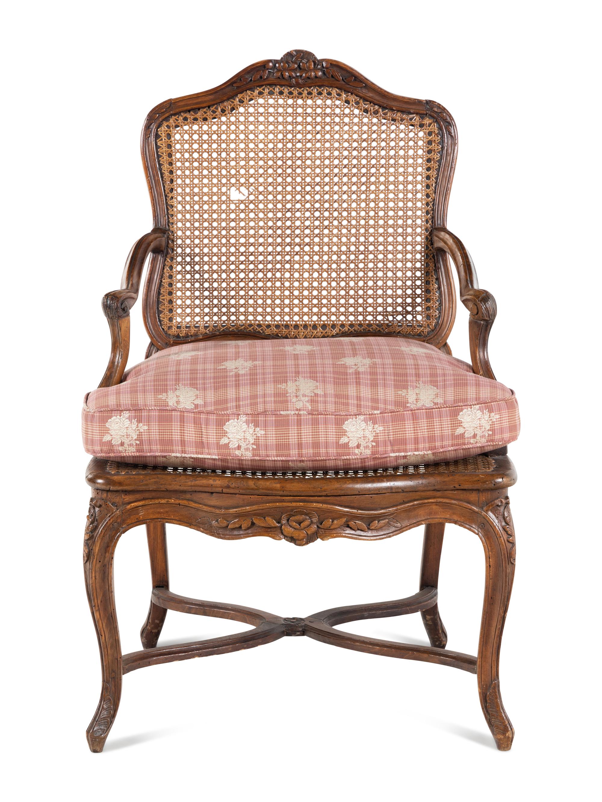 A Régence Carved Walnut and Caned Fauteuil