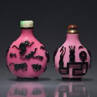 Two Chinese Carved Black-Overlaid Pink Glass Snuff Bottles, Qing Dynasty, Circa 1780-1900 — 1780-1900年 粉紅地套黑料鼻煙壺兩支